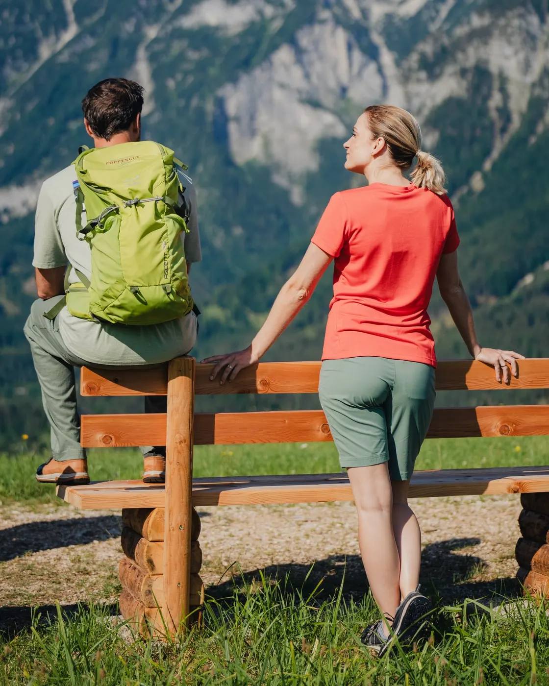 © Sarah Kreutzhuber Wanderpaar an einer Holzbank mit Blick auf die Berge