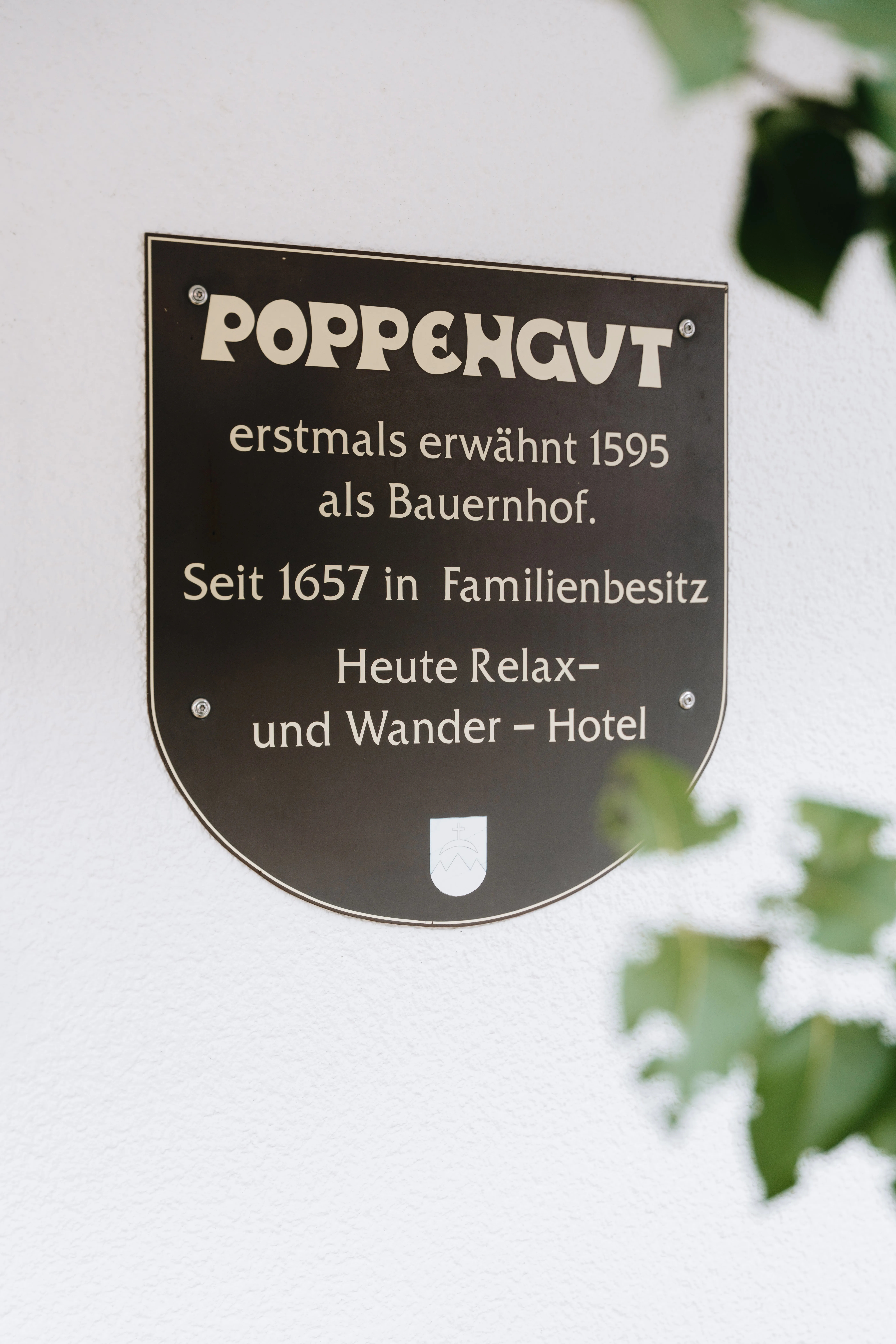 © Hartwig Winkler Wappenschild an der Hauswand — Poppengut, erstmals erwähnt 1595 als Bauernhof, seit 1657 in Familienbesitz, heute Relax- und Wanderhotel