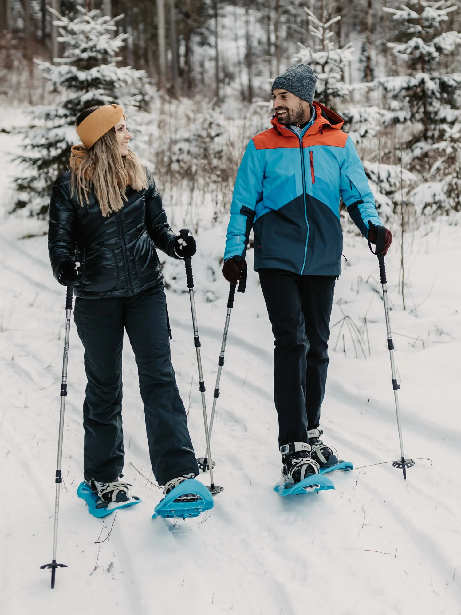 © Selina Flasch Photography Paar mit Schneeschuhen und Stöcken im verschneiten Wald